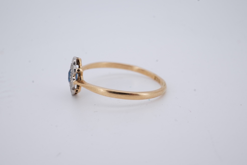A 1920's yellow metal, stamped 18ct, sapphire and diamond set oval cluster ring, size V, gross weight 2.3 grams. Condition - poor to fair